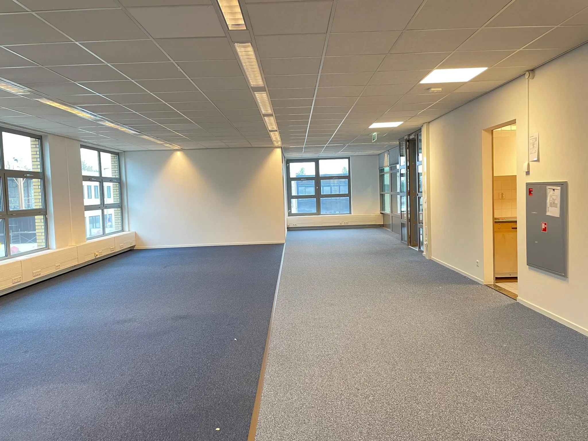 Licht en ruim kantoorpand aan de Rivium 3e Straat met grote ramen en een aparte keukenruimte.